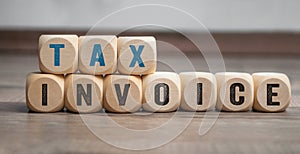 Cubes, dice or blocks with tax invoice on wooden background