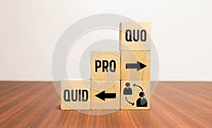 Cubes and dice with business message quid pro quo on wooden background