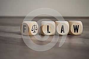 Cubes and dice with Flaw and Law on wooden background photo