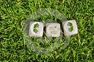 Cubes and dice in the green grass with zero waste and recycling logo