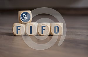 Cubes and dice with LIFO and FIFO accounting on wooden background
