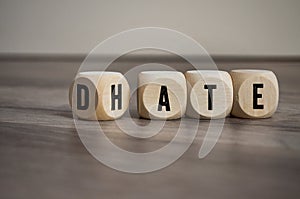 Cubes and dice with the opposite of hate and date on wooden background