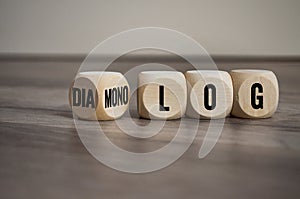 Cubes and dice on wooden background with the german words for dialogue and monologue - dialog und monolog