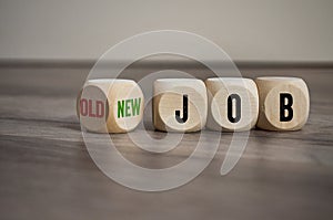 Cubes and dice on wooden background with word New Job versus old job