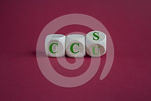 Cubes form the expression CCU and CCS. Beautiful red background. Reduce the