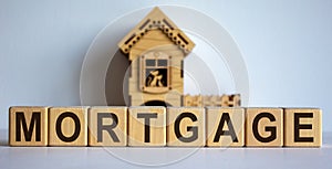 Cubes form the word `mortgage` in front of a miniature house