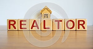 Cubes form the word realtor in front of a miniature house