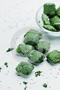 cubes of frozen spinach on a white surface