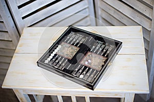 Cubes and game pieces on a backgammon board, on wooden table