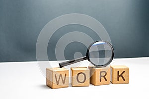 Cubes labeled work and magnifying glass. Concept of job search or workers. Human resources, hiring specialists and specialized