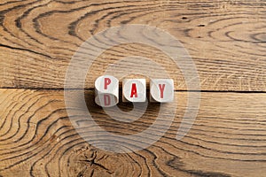 Cubes with letter forming either the word PAY or DAY