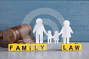 Cubes with letters, judge gavel and family figure on light table. Family law concept