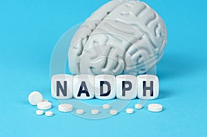 Cubes lie on the table among the pills and imitation of the brain. The text on the dice - NADPH photo