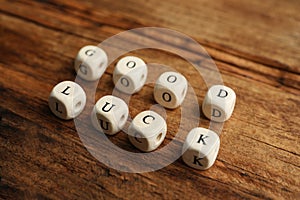 Cubes with phrase GOOD LUCK on wooden table