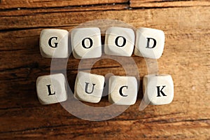 Cubes with phrase GOOD LUCK on wooden table
