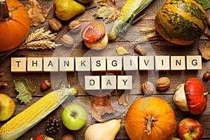 Cubes with phrase THANKSGIVING DAY, autumn fruits and vegetables on background, flat lay. Happy holiday