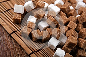 Cubes of white and brown sugar on a bamboo napkin