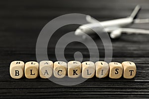 Cubes with word Blacklist on black wooden table, closeup
