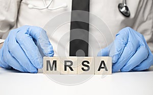 cubes with the word mrsa on doctor's hand. Care concept