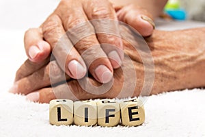 Cubes with the words life on the background of the hands of an e