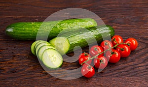 Cucumber amd tomatoes on wooden table