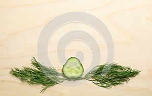 Cucumber and dill twigs on chopping board