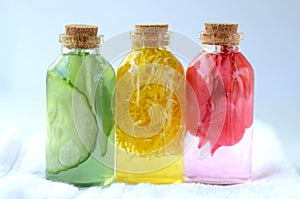 Cucumber, marigold and rose infusions in glass bottles