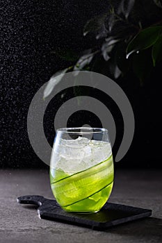 Cucumber mocktail on dark background with splashes of water