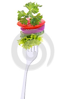 Cucumber, onion, tomato and parsley on a fork. photo