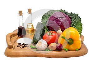 Cucumber, pepper, onion, garlic, cabbage leaves,tomato and red cabbage on a plateau with oil, vinegar, pepper and salt