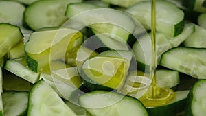 Cucumber salad. Pour olive oil on sliced cucumbers, rotation. Healthy food concept