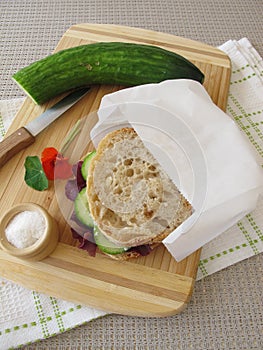 Cucumber sandwich in greaseproof paper bag