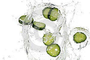 Cucumber slices and tomato, onion, fallen in water on a white background, top view