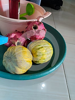 cucumber suri and dragon fruit on a green container