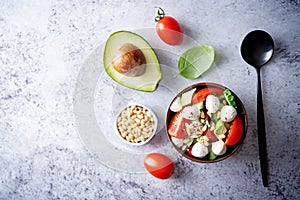 Cucumber tomato avocado mozzarella salad in a bowl