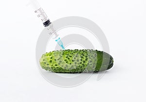 Cucumber on a white background in which the syringe gmo and nitrates are pricked, close-up, nitrates and genetically modified photo