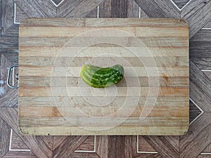 Cucumber on a wooden surface. Fresh cucumber on a cutting board. Cucumber for salads, appetizers, fried foods, soup and stews.