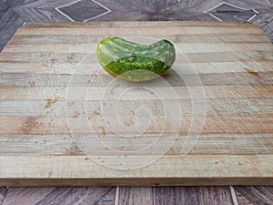 Cucumber on a wooden surface. Fresh cucumber on a cutting board. Cucumber for salads, appetizers, fried foods, soup and stews.