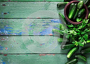 Cucumbers on old green wooden table.