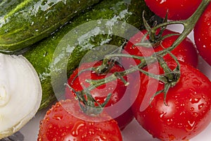 Cucumbers, onion and red tomatos on white plate.