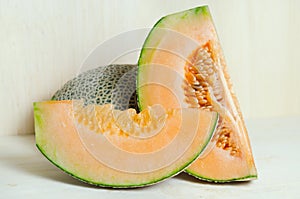 Cucumis melo or melon with half and seeds on wooden plate (Other names are cantelope, cantaloup, honeydew, Crenshaw, casaba, Per