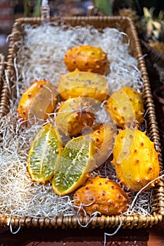 Cucumis metuliferus whole and cut in wooden box on shavings of paper for sale in the market