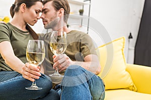 cuddling couple drinking wine together on couch