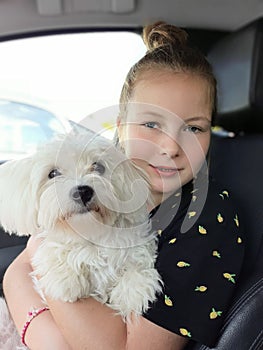 Cuddly hug of a girl and her pet in a car