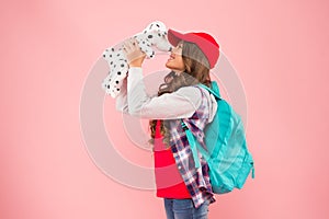 Cuddly little plaything. Happy small child play with toy present on pink background. Little girl smile with toy dog