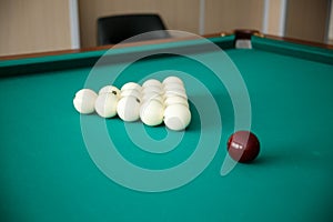 Cue ball for Russian billiards on the table. White billiard balls on the background.