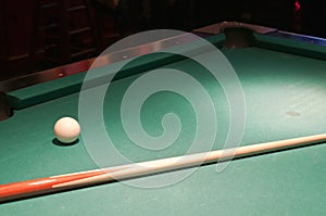 Cue ball and stick on pool table photo