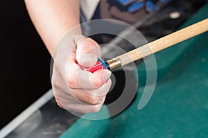 Cue stick with chalk block on green billiard table.Chalk block on pool table