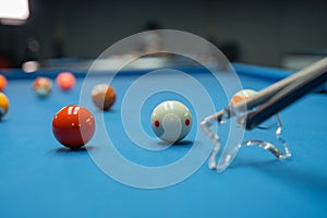 a cue stick poking the white ball using the bridge