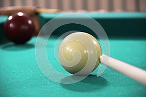 Cue, two billiard balls on a green cloth table, cue ball and white ball. Russian Billiards